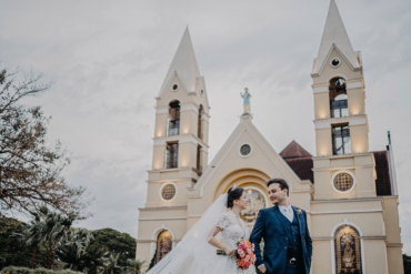 Casal em Frente à Igreja em Dia de Casamento