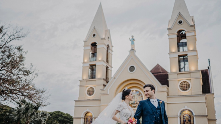 Casal em Frente à Igreja em Dia de Casamento