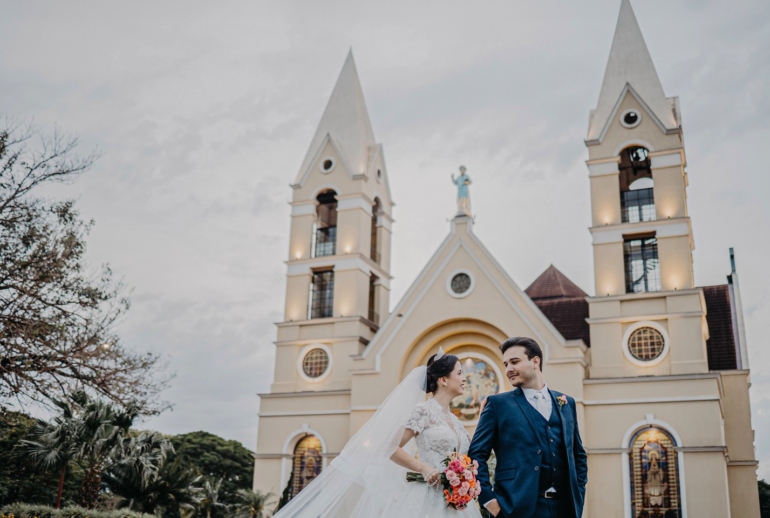 Casal em Frente à Igreja em Dia de Casamento