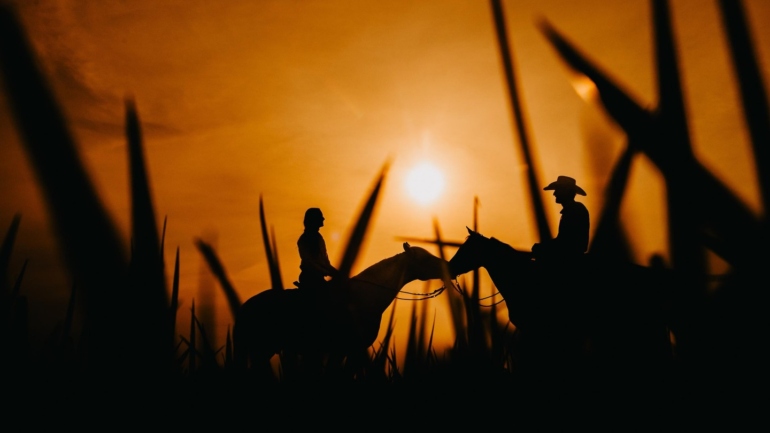 Silhuetas em Cavalgada ao Pôr do Sol