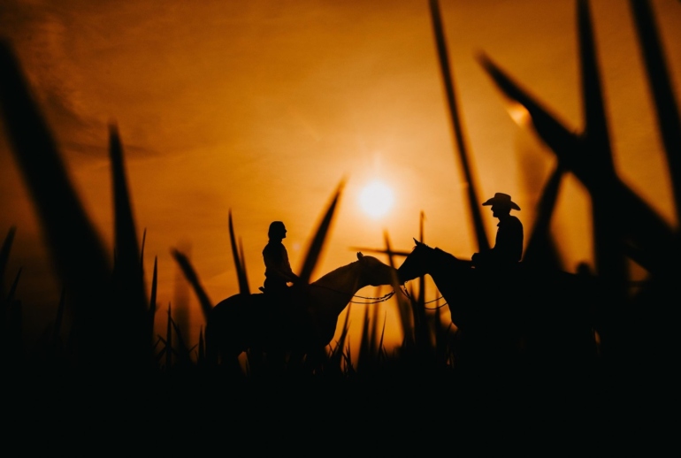 Silhuetas em Cavalgada ao Pôr do Sol