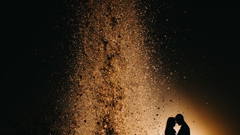 Noivos se Beijando com Luzes ao Fundo em Casamento