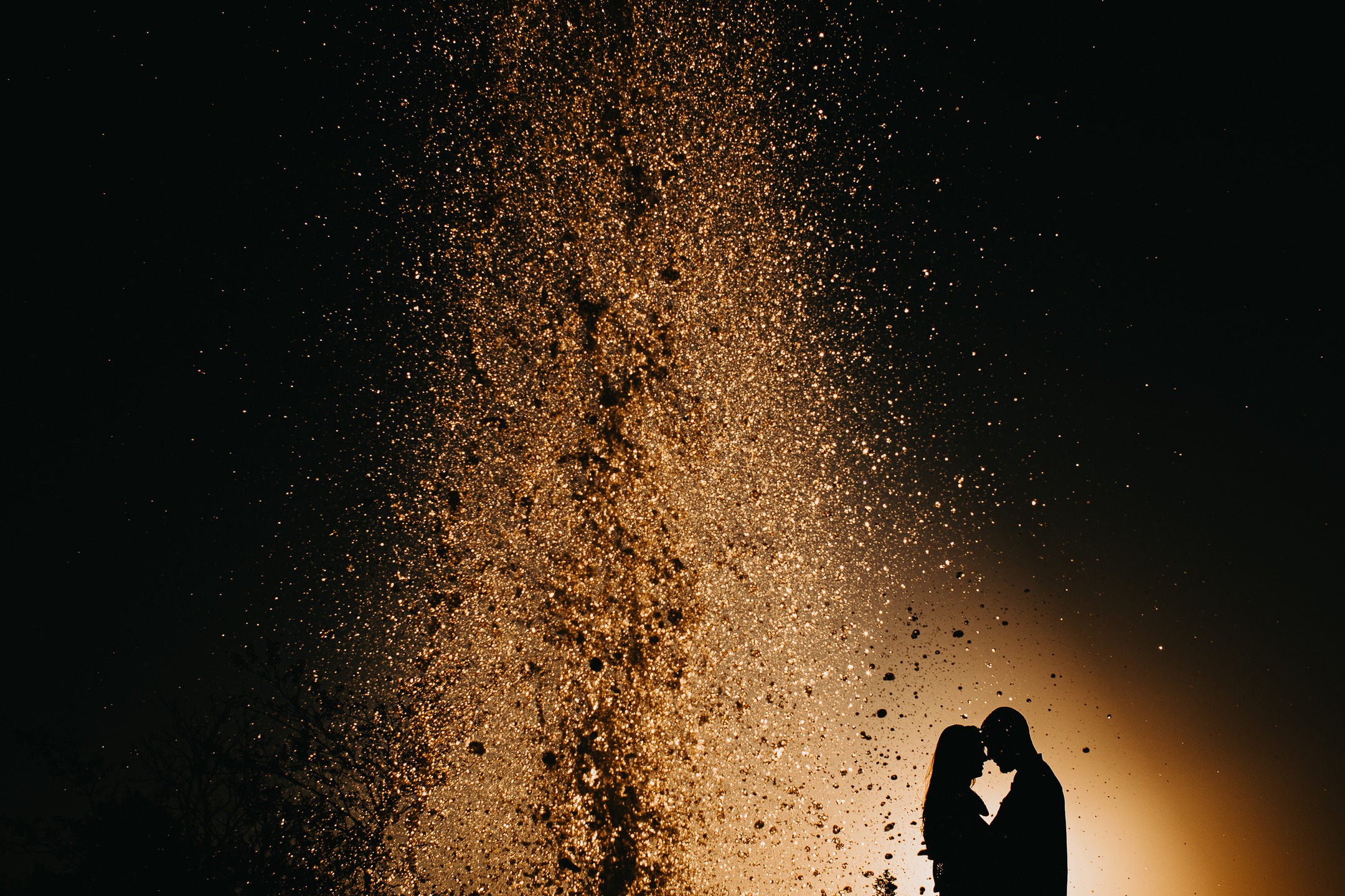 Noivos se Beijando com Luzes ao Fundo em Casamento